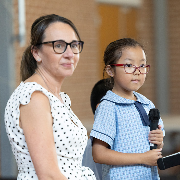 Dedicated Teachers at St John Vianney's Catholic Primary Doonside. Music teacher assisting student with performance.