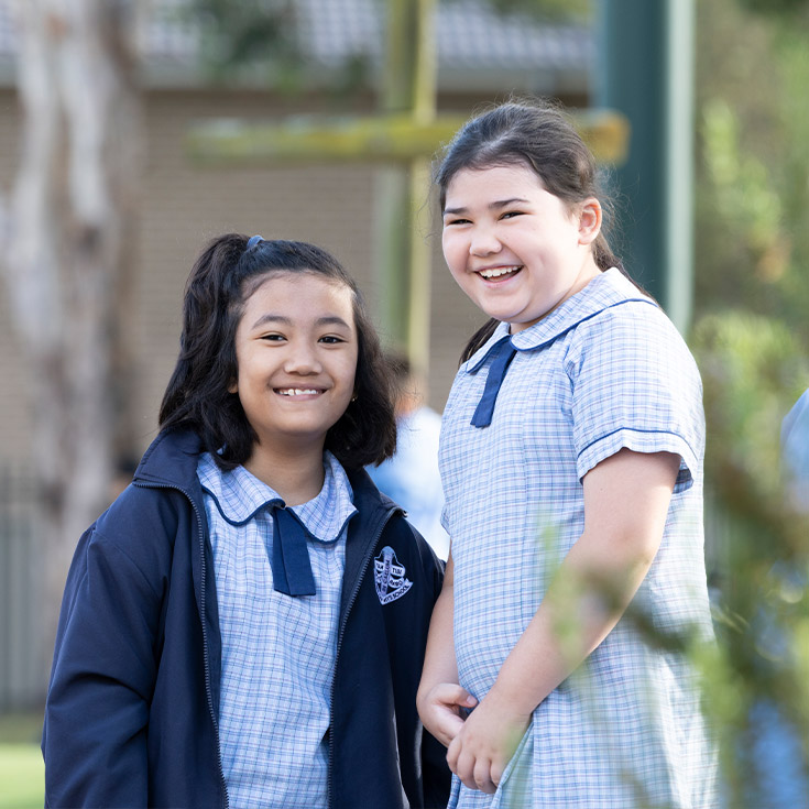 Happy students from St John Vianney's Doonside. 2 girls are standing outdoors.