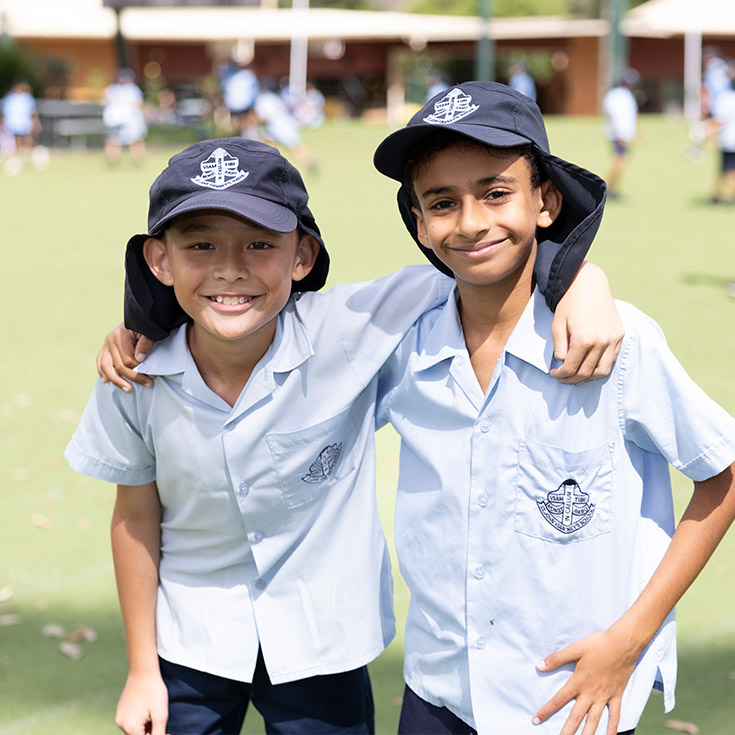 Happy students from St John Vianney's Doonside. 2 boys are standing outdoors.