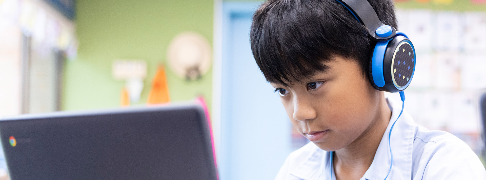 St John Vianney's Doonside student wearing headphones and working off laptop