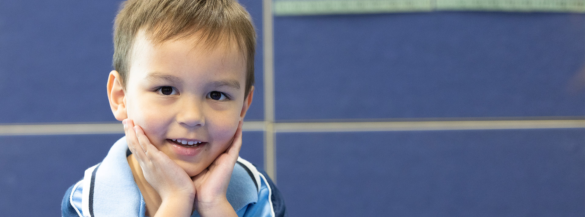 Student reading a book at his desk at St John Vianney's Primary School Doonside