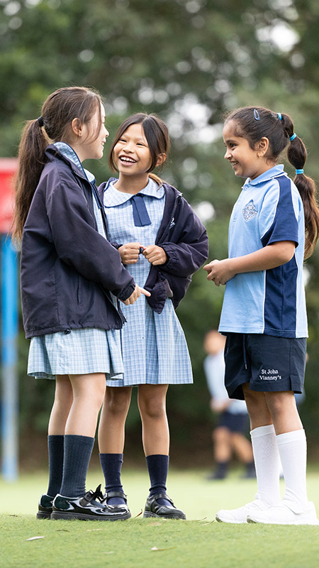 Happy students from St John Vianney's Doonside. 3 girls are standing outdoors.