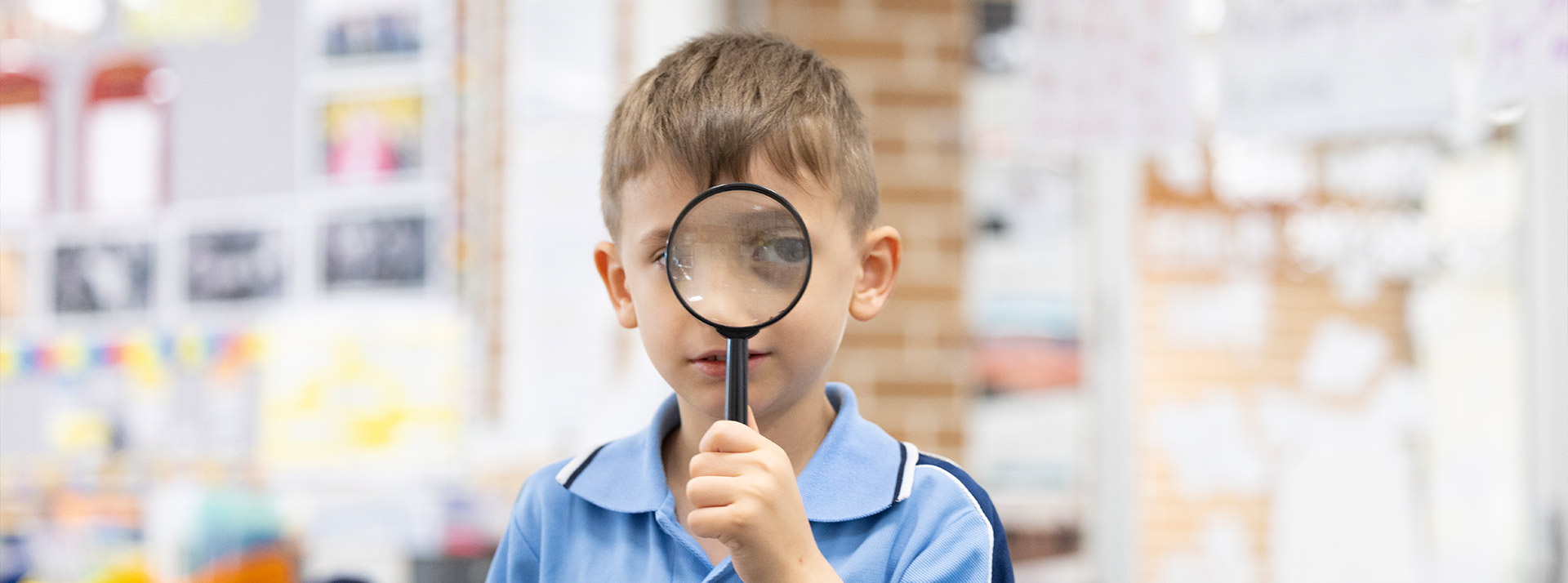 St john Vianney's Doonside student holding a magnifying glass
