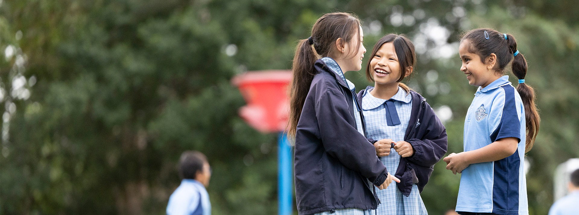 Happy students from St John Vianney's Doonside. 3 girls are standing outdoors.