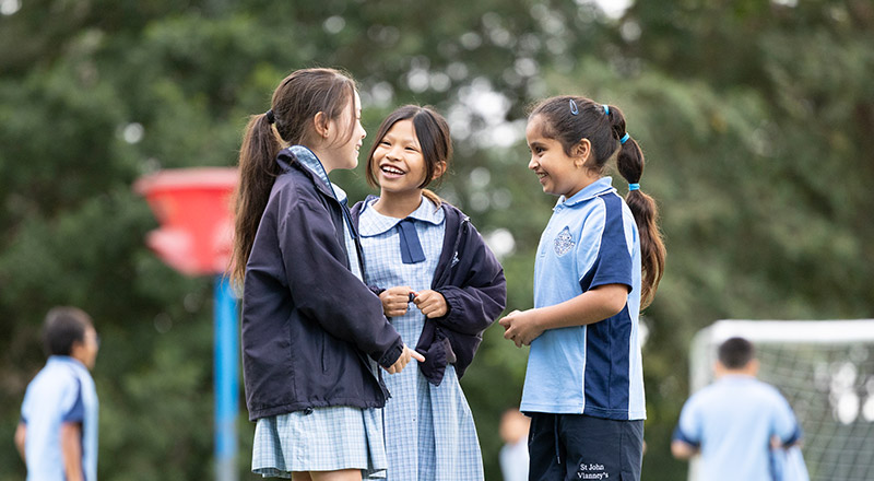 Happy students from St John Vianney's Doonside. 3 girls are standing outdoors.