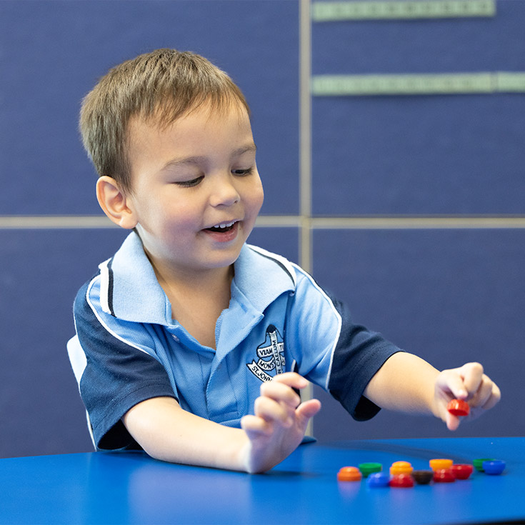 Smiling student at St John Vianney's Doonside. The student is learning to count.